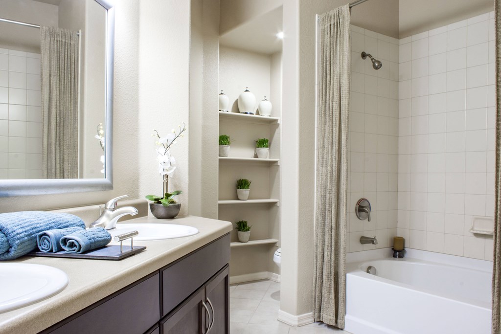 A bathroom with a white tub and a white sink.