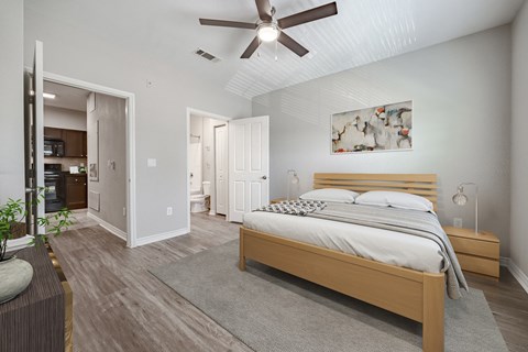 A bedroom with a large bed and a ceiling fan.