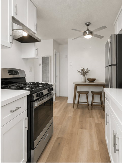 A modern kitchen with a black stove top oven and white cabinets.
