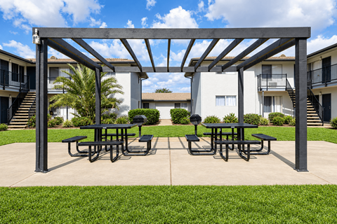 A patio with a table and chairs under a pergola.