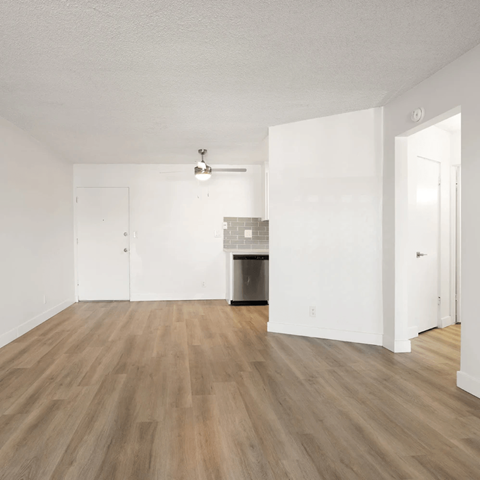 A room with a fireplace and wood flooring.