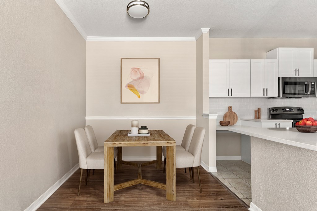 A dining table with chairs and a painting on the wall.