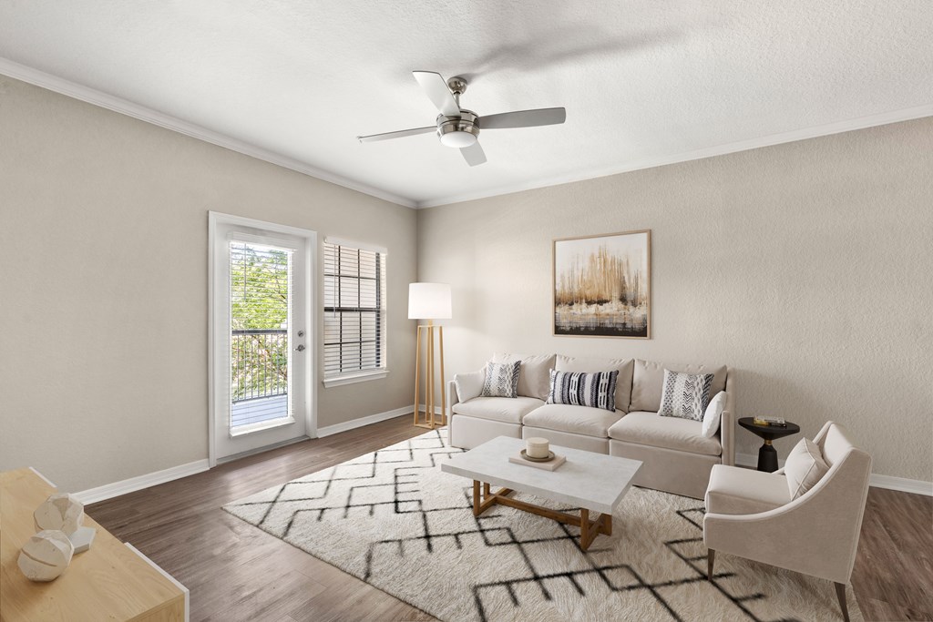 A living room with a white couch, a coffee table, and a ceiling fan.