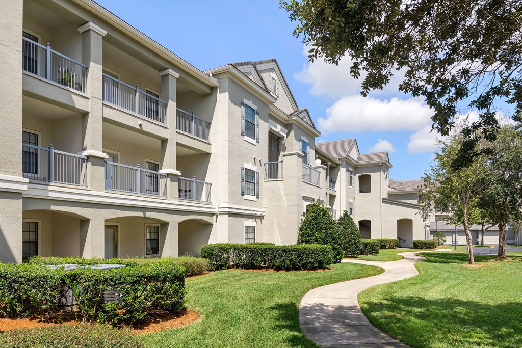 Apartment complex with a walkway in front.