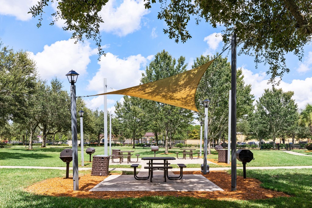 A park with a picnic table and a yellow canopy.