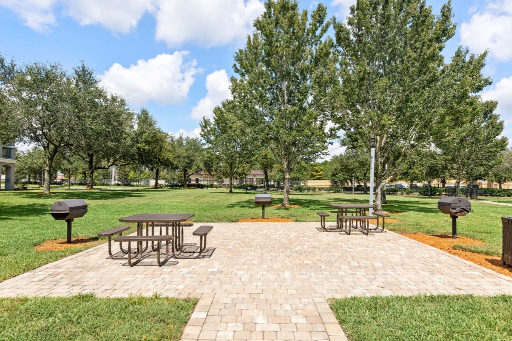 A park with picnic tables and trees.