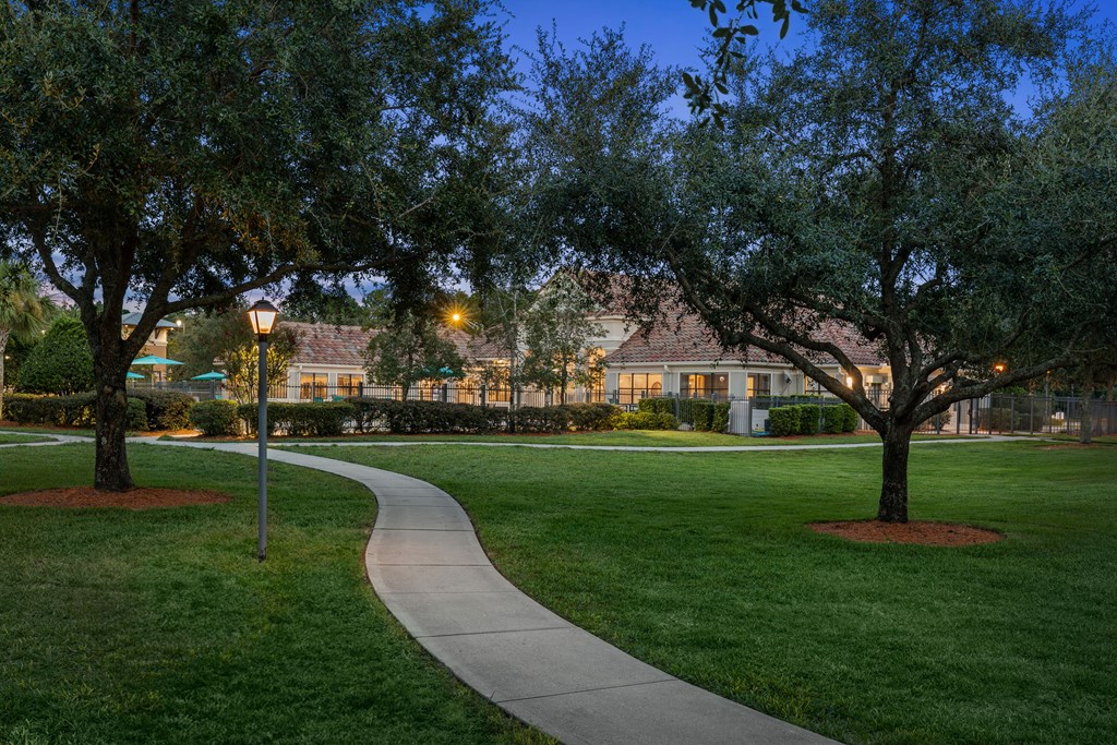 A pathway leads through a grassy area with trees on either side.