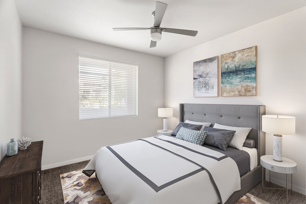 A bedroom with a large bed and a ceiling fan.