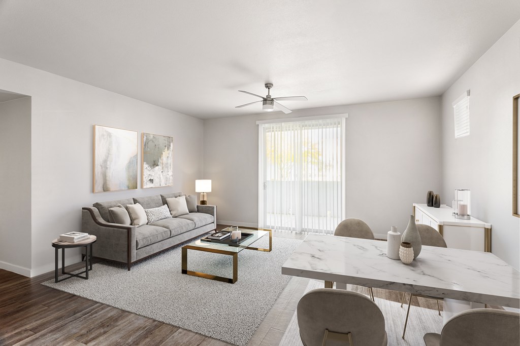 A modern living room with a grey sofa, a white coffee table, and a grey rug.