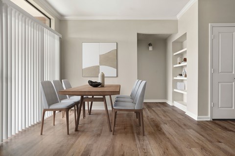 A dining room with a wooden table and chairs.