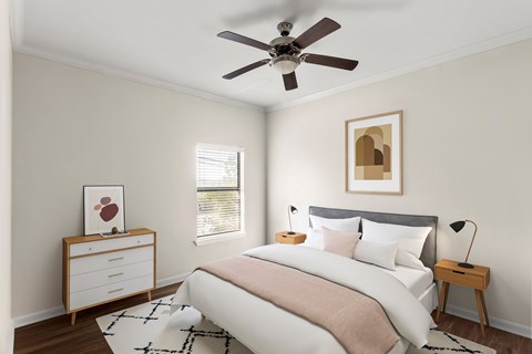A bedroom with a bed, a dresser, and a ceiling fan.