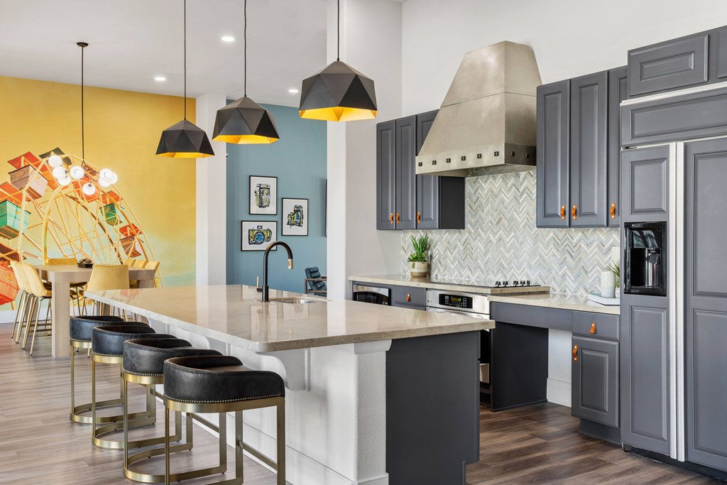 A kitchen with a white island and grey cabinets.