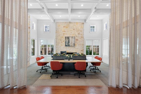 A conference room with a stone fireplace and a long table with chairs.