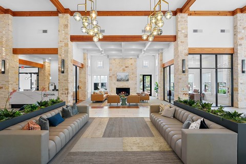A large, modern living room with a fireplace and a long, curved couch.
