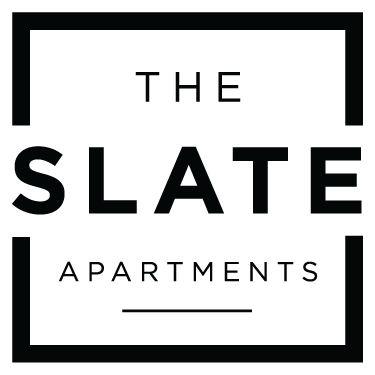 The image shows a logo with the text "THE SLATE APARTMENTS" in a bold, black font on a green background.