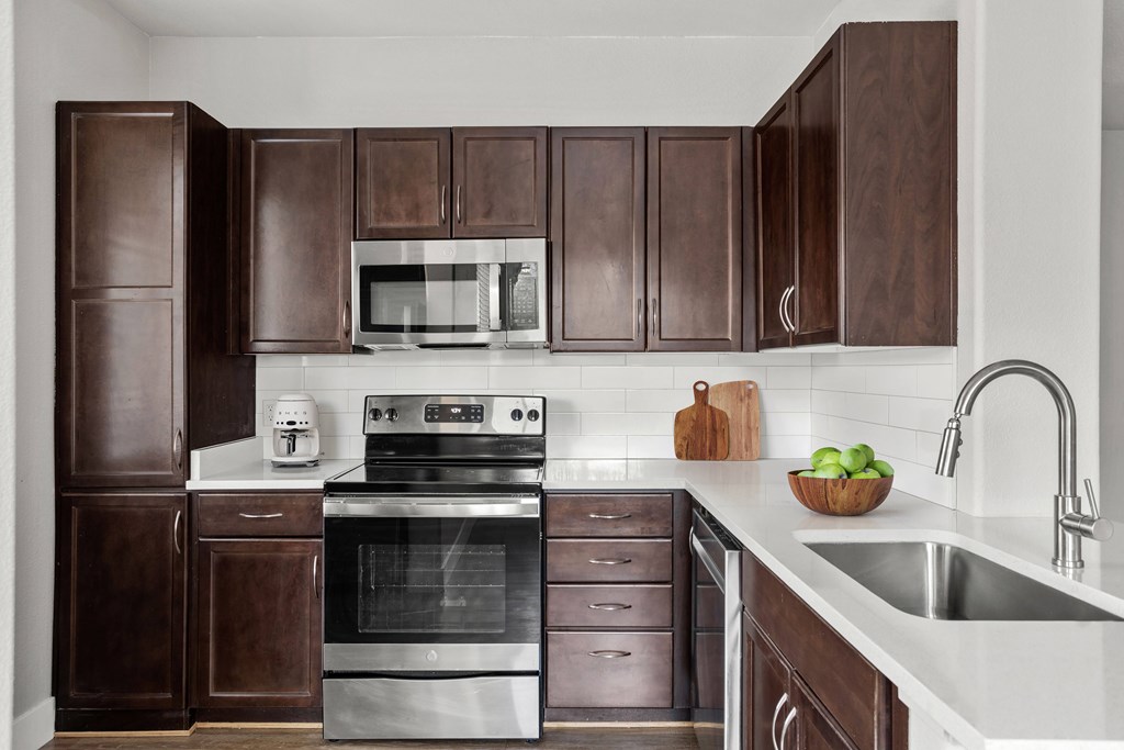 A kitchen with brown cabinets and stainless steel appliances.