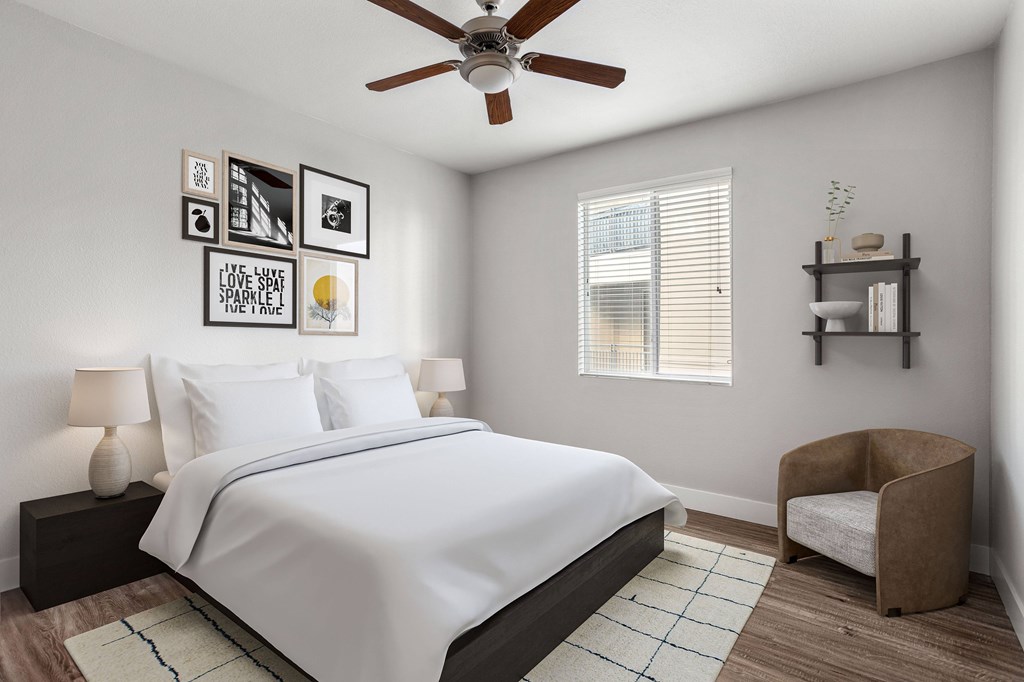 A bedroom with a bed, chair, and pictures on the wall.