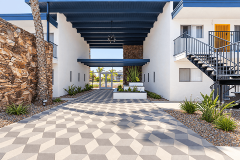 A modern house with a checkered floor leading to the front door.