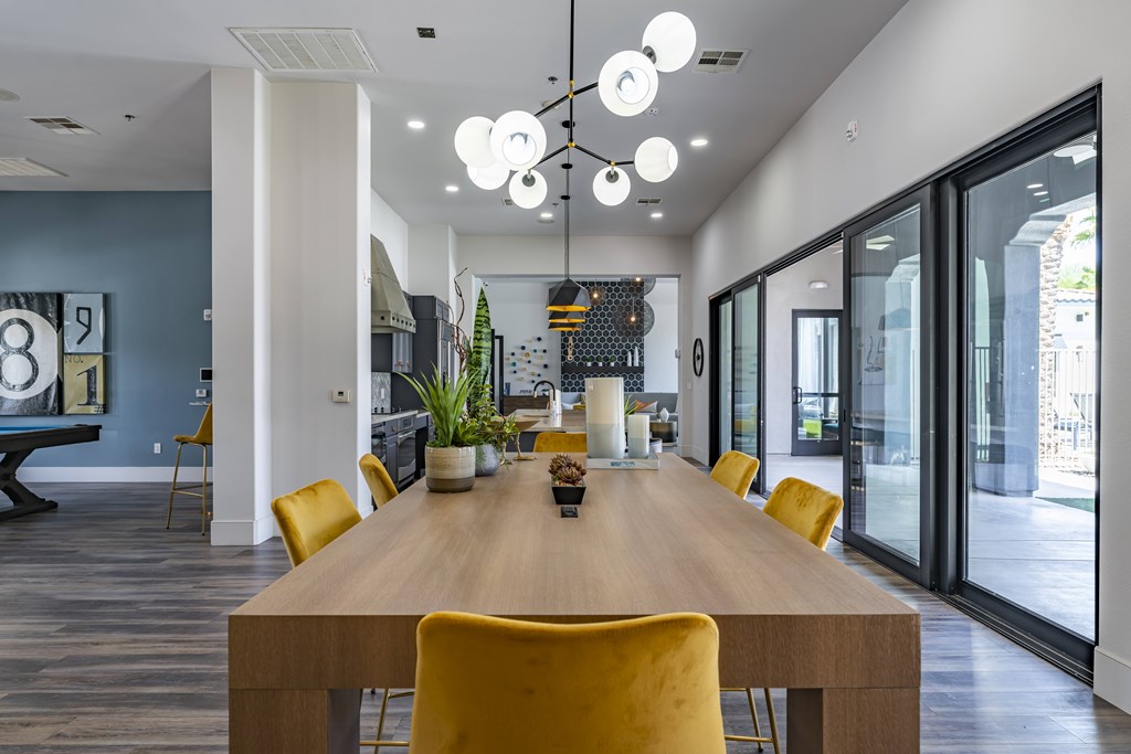 A conference room with a long table and yellow chairs.
