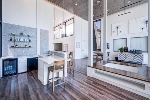 A kitchen with a white counter top and wooden floors.