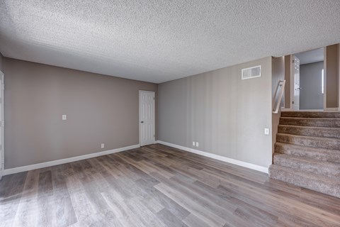 A room with wooden flooring and a staircase.