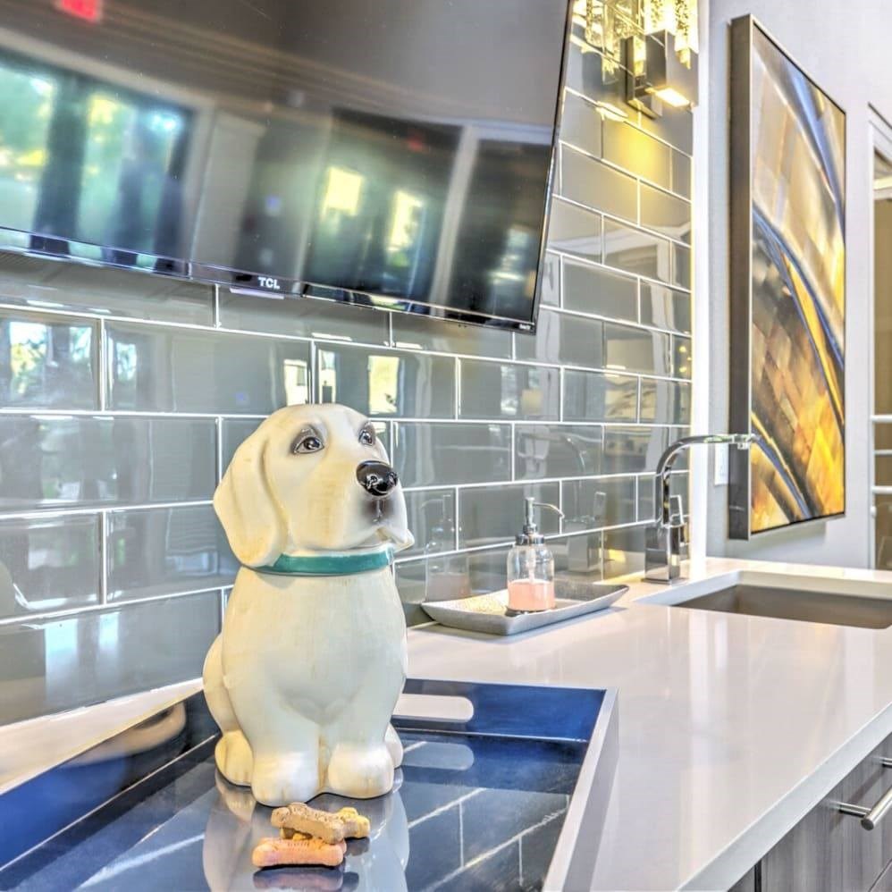 A dog statue is sitting on a countertop in a modern kitchen.