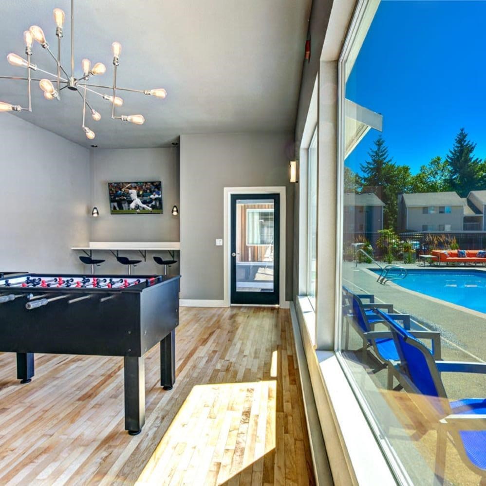 A room with a pool table and a foosball table.