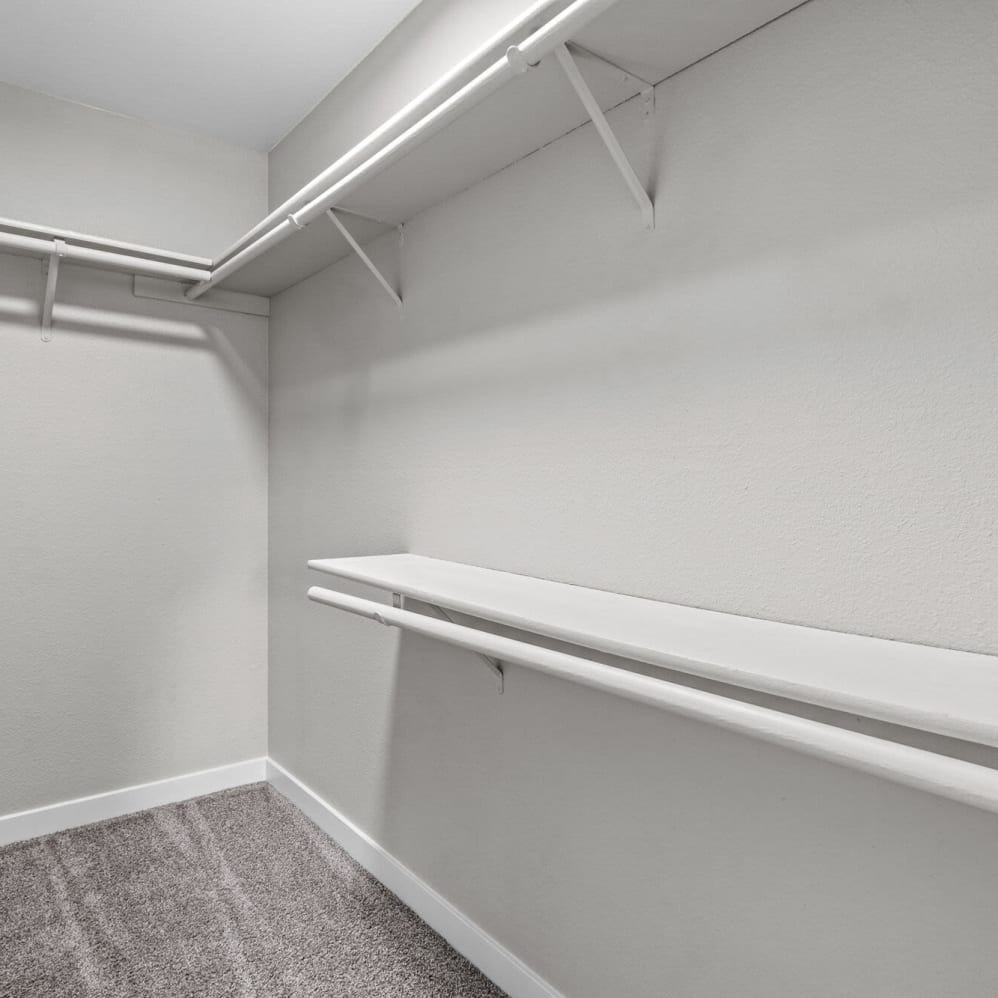 A white closet with two shelves and a hanging rod.