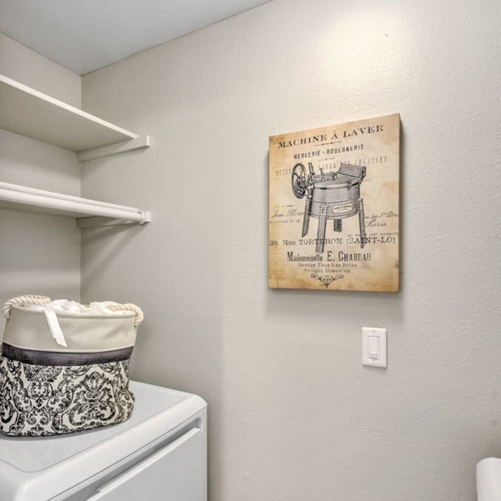 A laundry room with a washer and a sign on the wall.