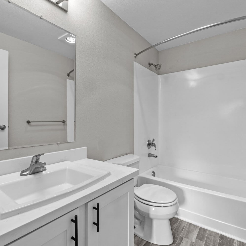 A white bathroom with a toilet, sink, and bathtub.