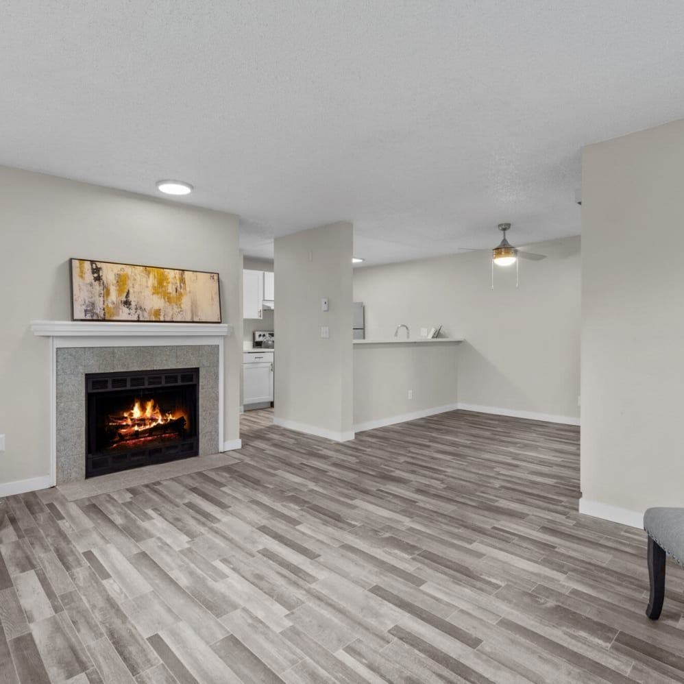 A living room with a fireplace and a painting on the wall.
