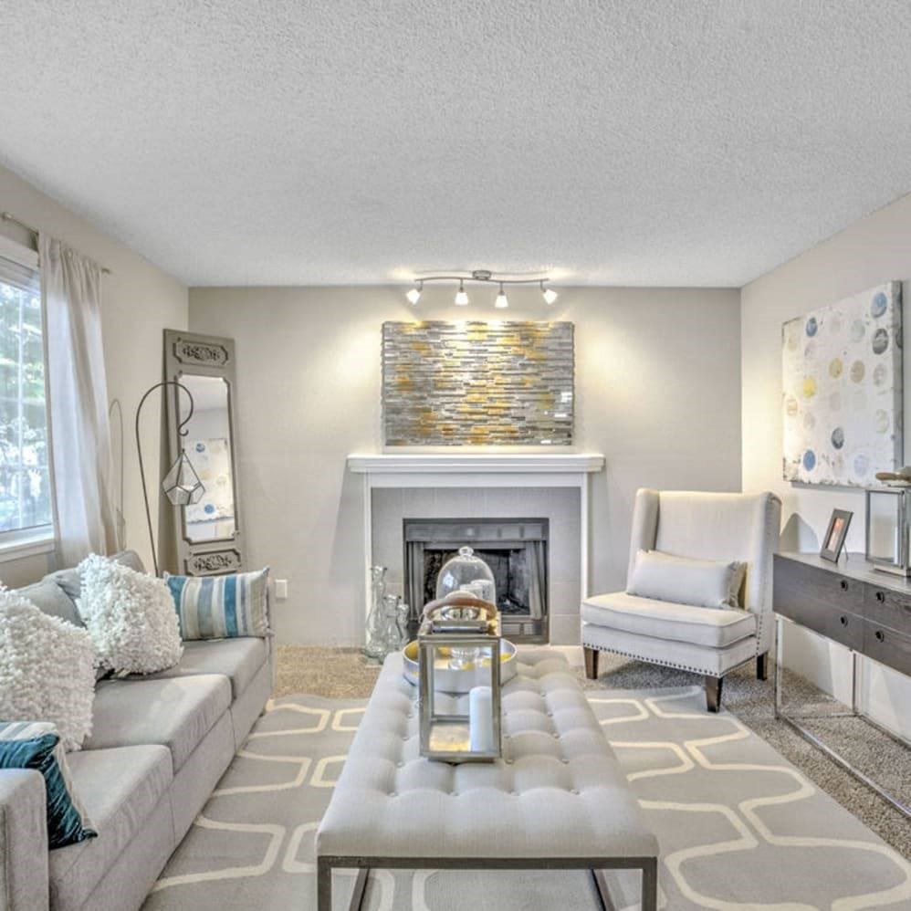 A modern living room with a fireplace and a grey sofa.