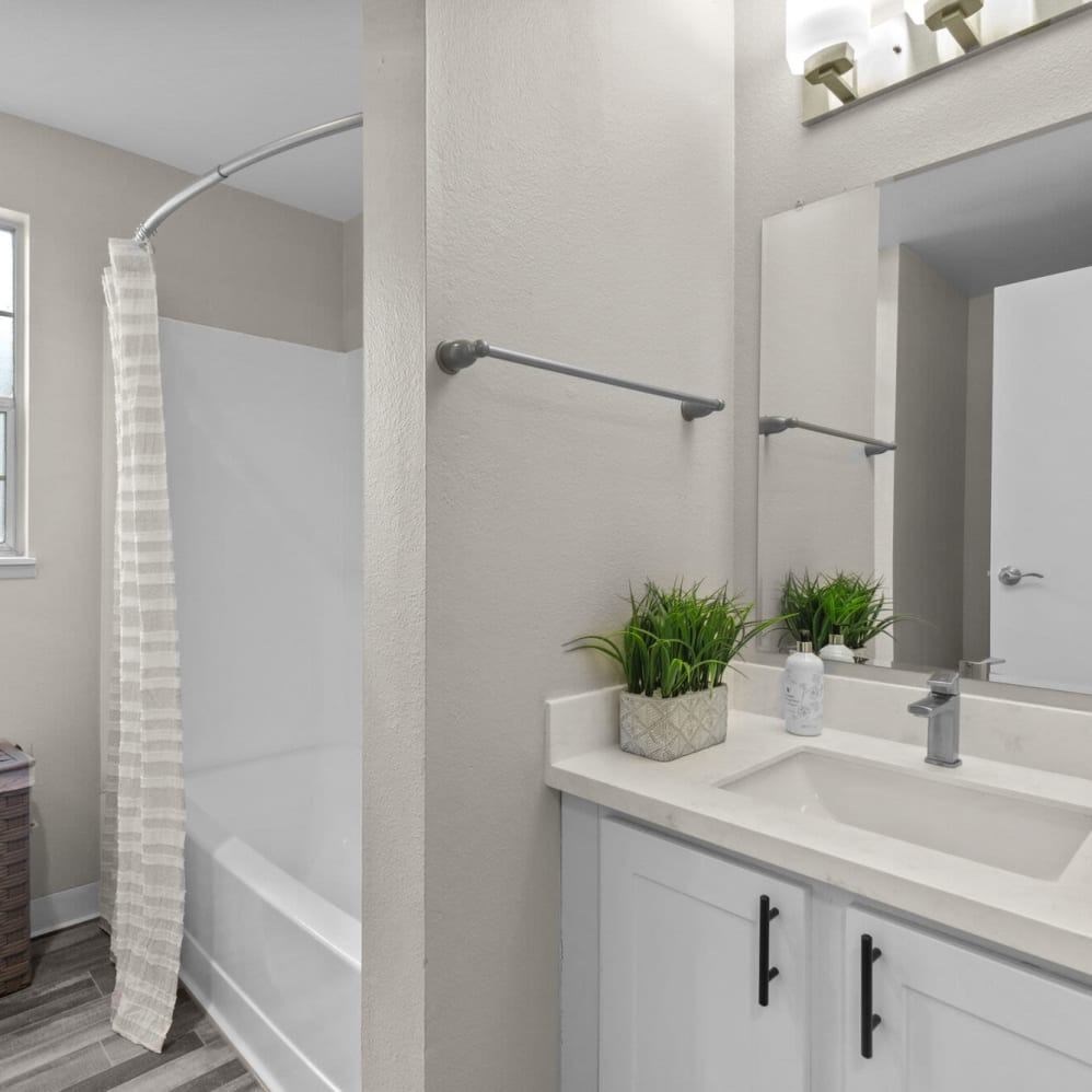 A white bathroom with a white tub, sink, and towel.
