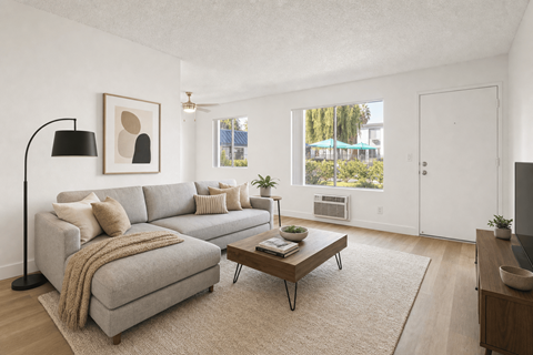 A living room with a grey couch, a coffee table, and a lamp.