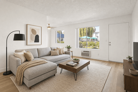 A living room with a grey couch, a coffee table, and a lamp.