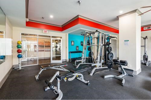 A gym with a variety of equipment including weights and cardio machines.