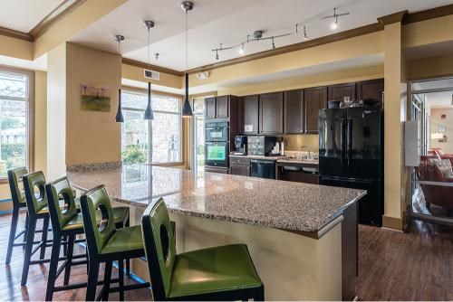 A kitchen with a granite countertop and black appliances.