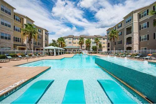 A large swimming pool in front of apartment buildings.