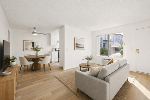A living room with a grey couch and a wooden floor.