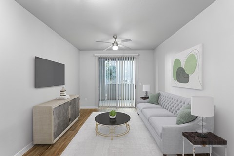 A living room with a grey sofa, a black coffee table, and a television on the wall.