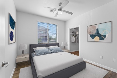 A bedroom with a bed, a ceiling fan, and two wall art pieces.