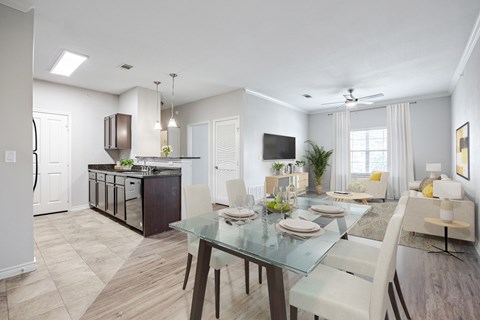 A modern dining room with a glass table and chairs.