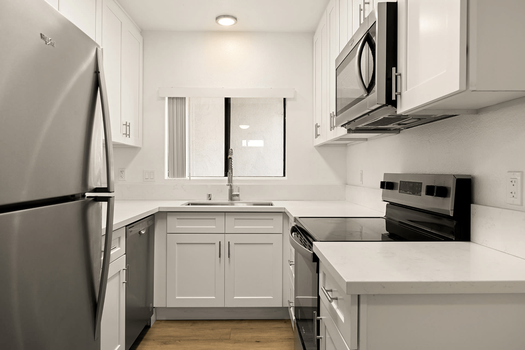 A kitchen with white cabinets and appliances.