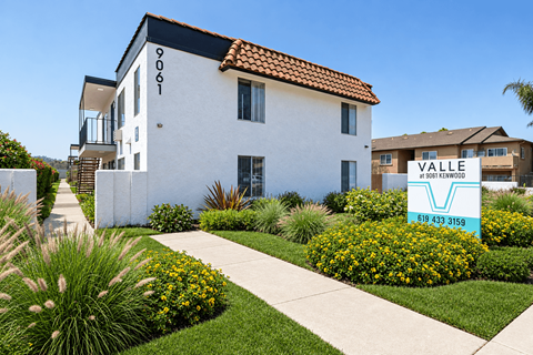 A white house with a blue sign in front of it that says "VALLE".