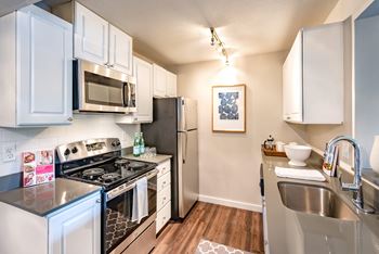 A kitchen with white cabinets and a black stove top.