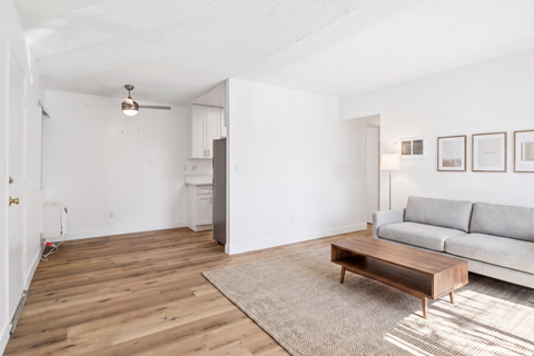 A living room with a grey couch and a wooden coffee table.