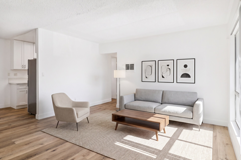 A living room with a grey couch, a chair, and a coffee table.