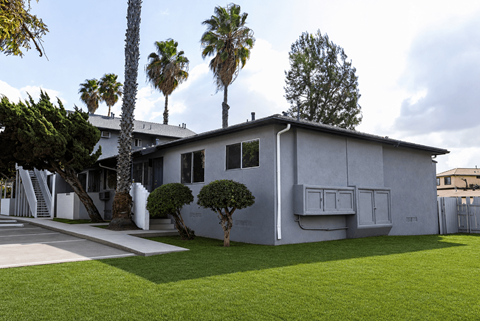 A modern house with a white exterior and a green lawn.