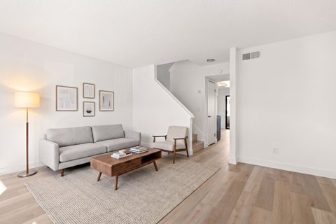 A living room with a grey couch and a wooden coffee table.