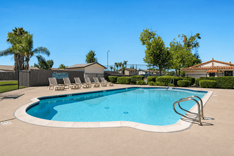 A large outdoor swimming pool with a metal ladder.